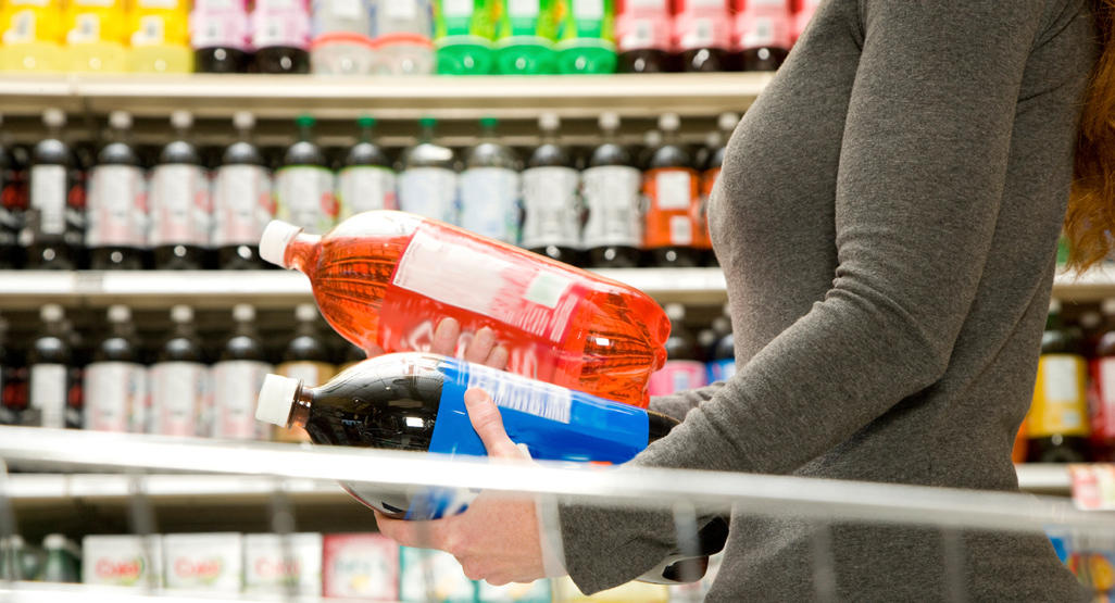 woman holding two liters of soda