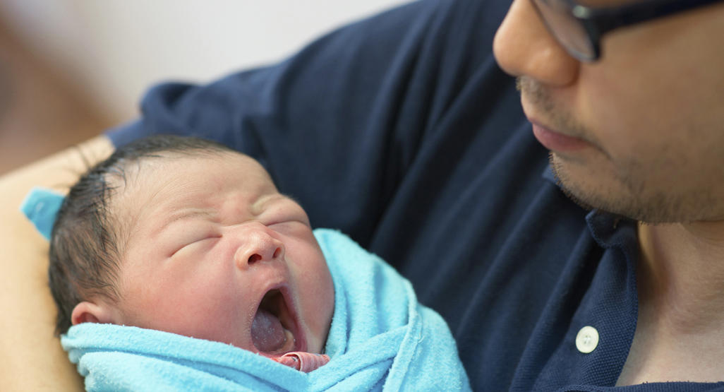 newborn in a blanket yawning