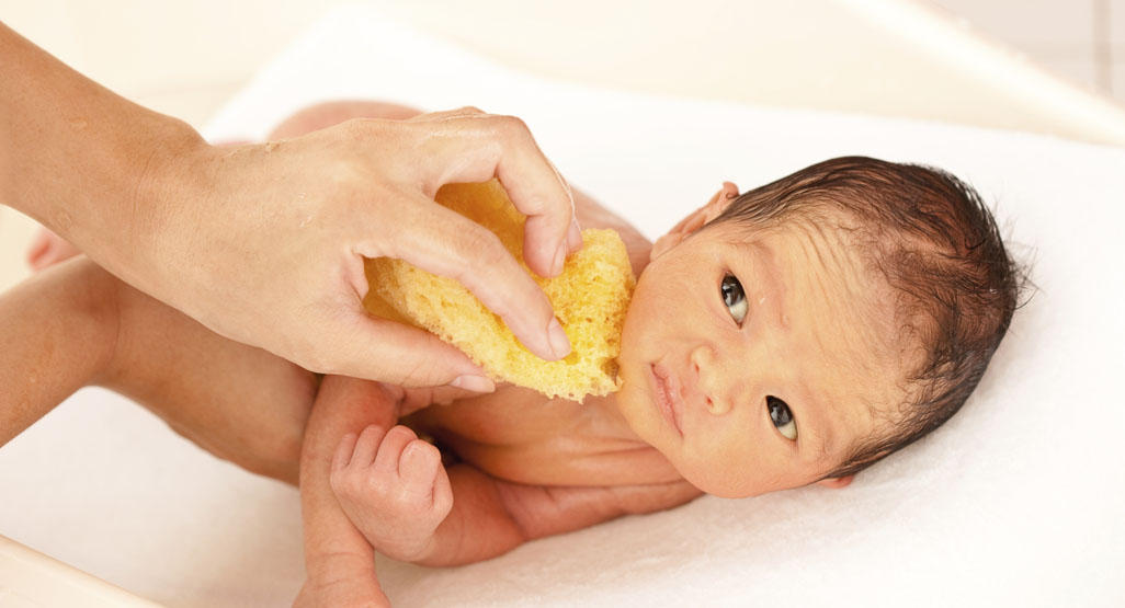 newborn baby getting a sponge bath