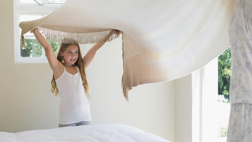 little girl making her bed