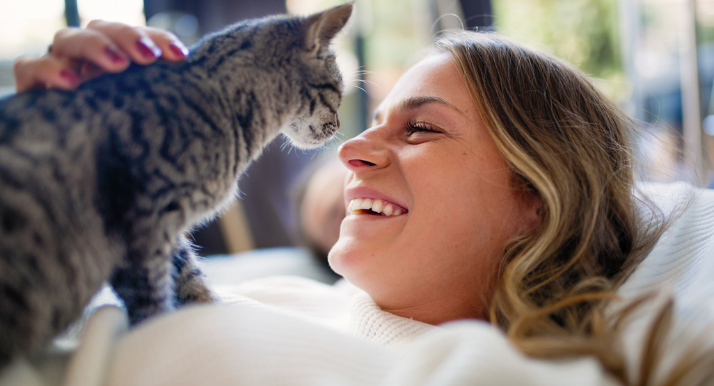 woman happily looking at cat