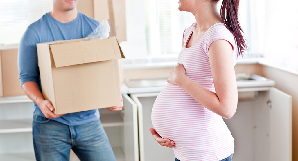 pregnant woman with her husband who is carrying a box