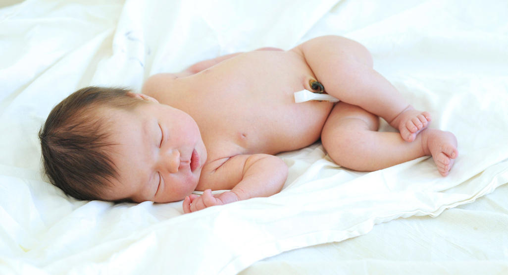 newborn sleeping on the side with umbilical cord stump