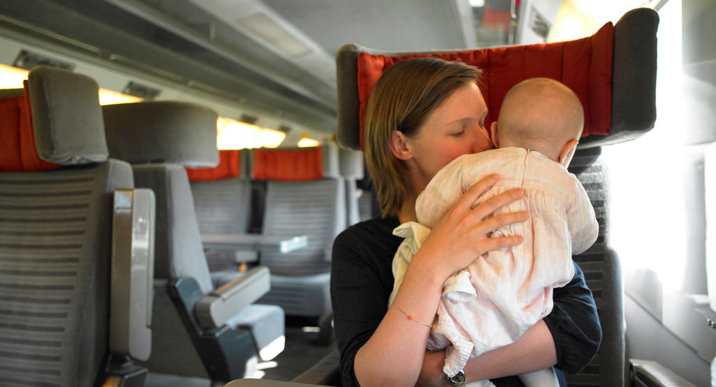 woman holding her baby in a train