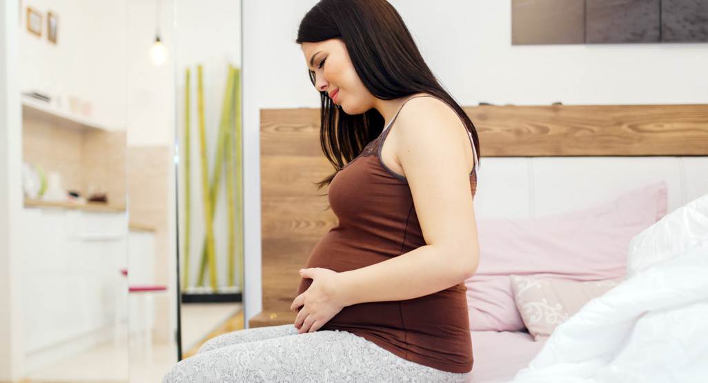 pregnant woman holding her belly