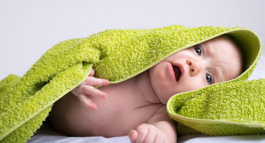 naked baby covered by a towel