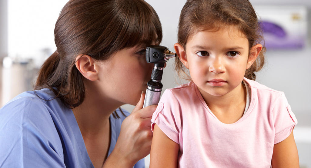 doctor checking a girl’s eardrum and the passage of the outer ear with otoscope