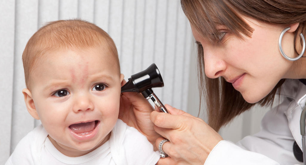 doctor is checking the baby’s ear with the otoscope