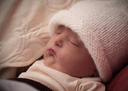 baby sleeping wearing a winter hat
