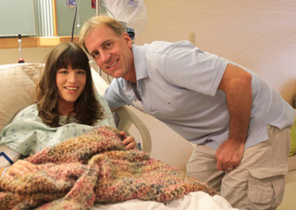 husband taking a photo with his wife in a hospital bed