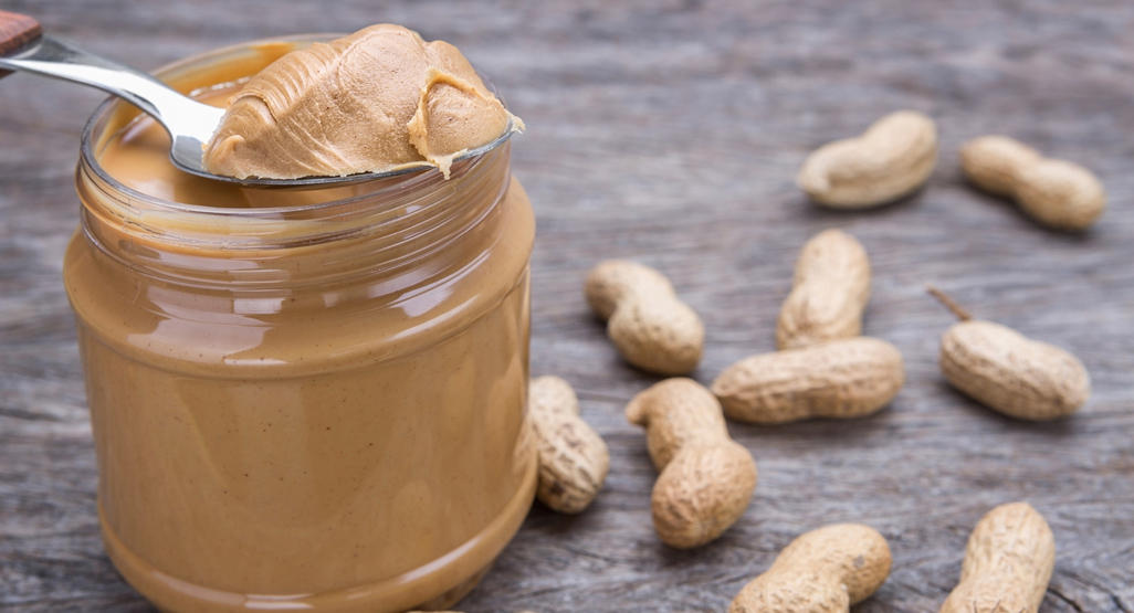 peanut butter jar surrounded by peanuts