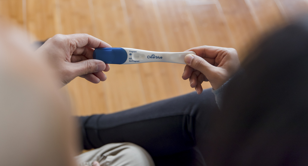 couple holding a pregnancy test in their hands