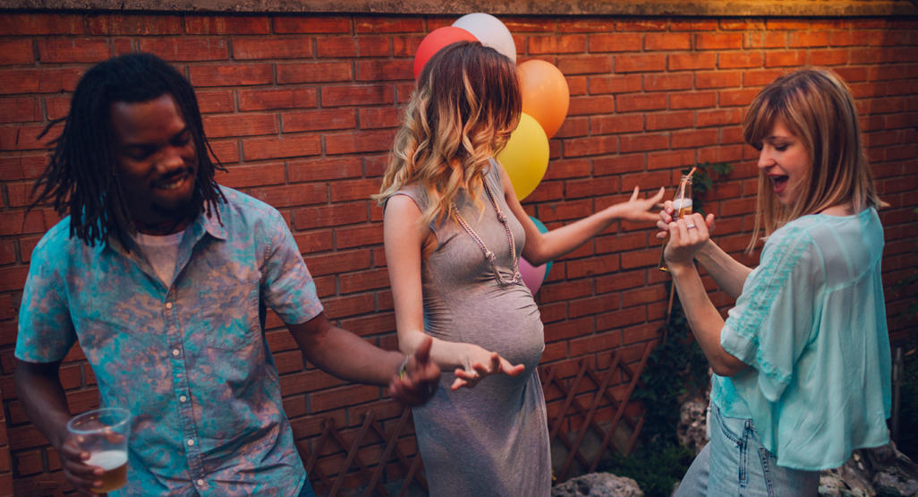 pregnant woman dancing with two people