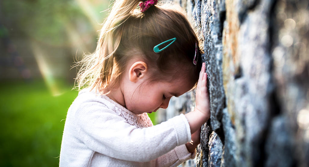 child banging her head against a wall