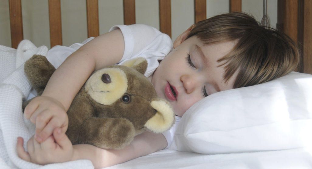 child sleeping with teddy bear