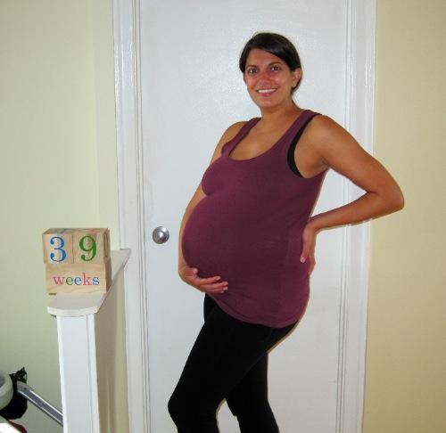 pregnant woman holding one hand on her belly and the second one on her back