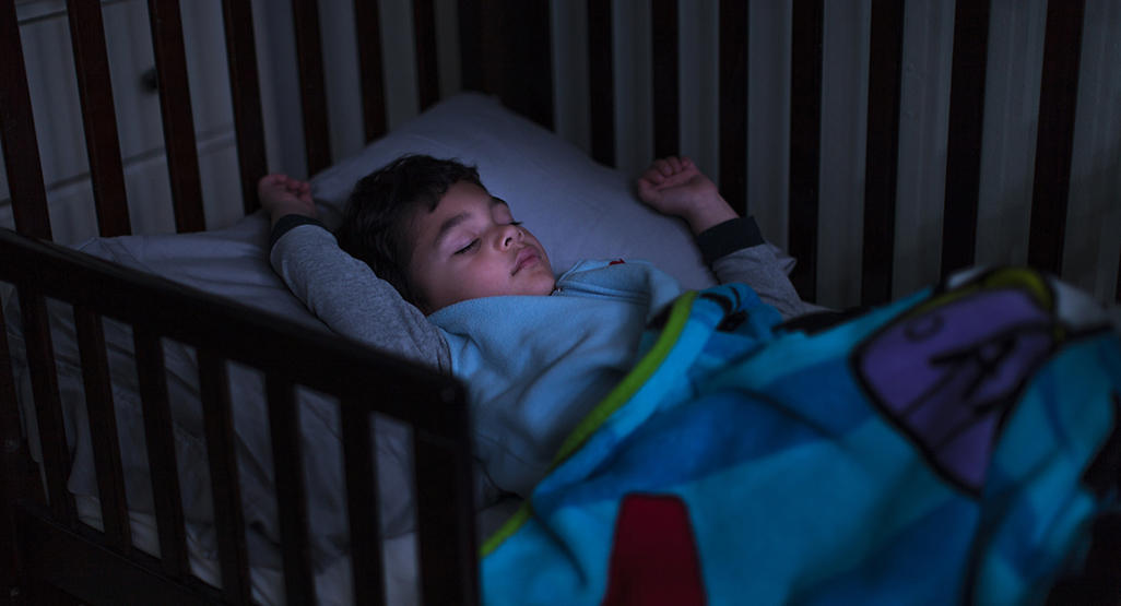 toddler sleeping in a crib