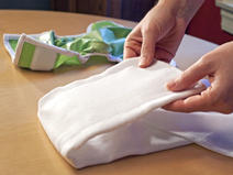 folding flat part of diaper towards middle, to match size