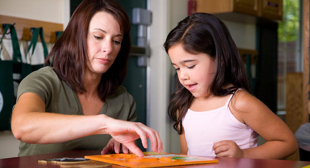 mother playing puzzles with her daughter