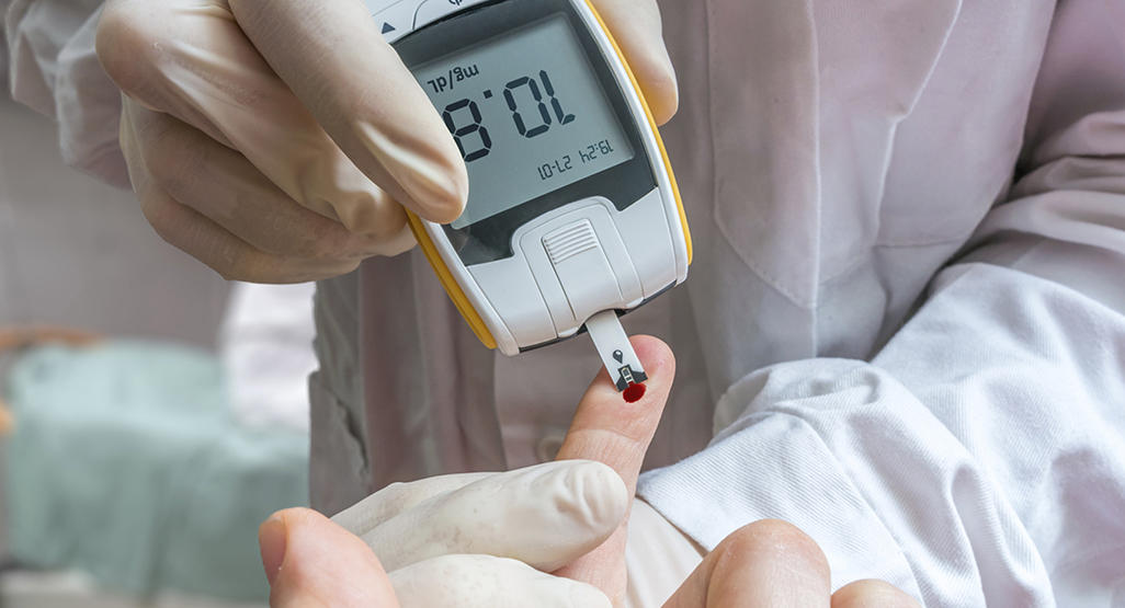 person getting his blood tested from a finger with a diagnostic device