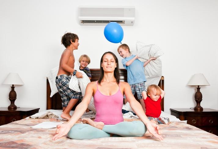 mom trying to find a piece doing yoga while four kids making noise behind her