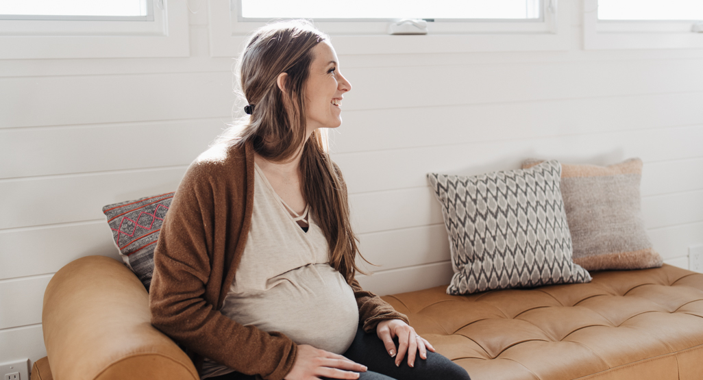 pregnant woman sitting down on couch