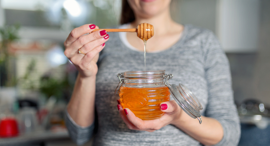pregnant woman holding a jar of honey
