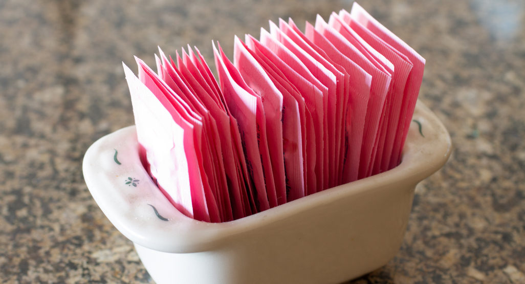 packets of artificial sweeteners in a bowl