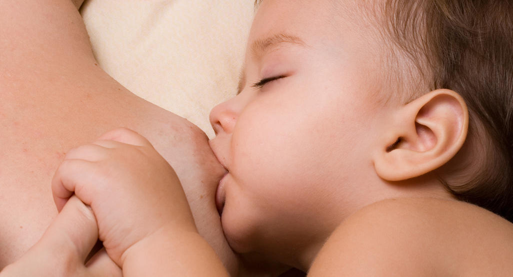 close up of a baby nursing at mothers breast