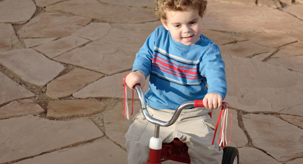little boy riding on a tricycle