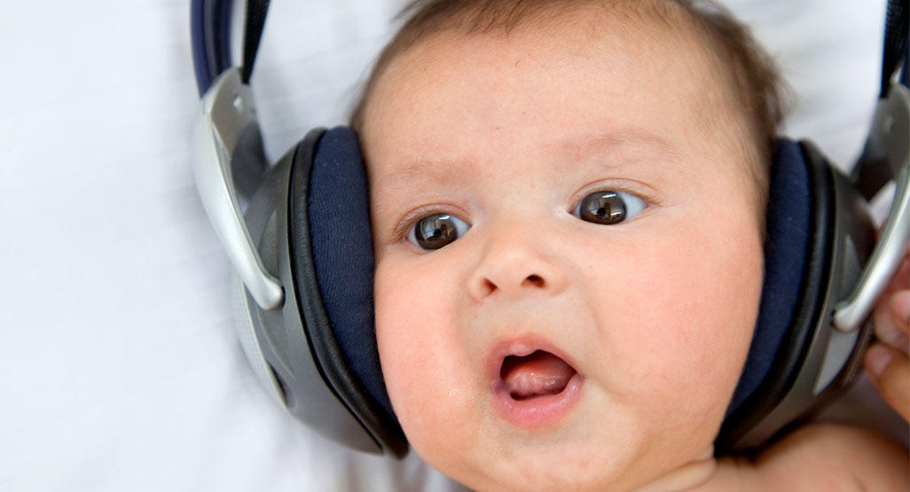 baby with big headphones over her ears
