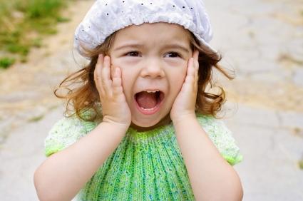 girl wearing a hat and screaming while standing outdoors