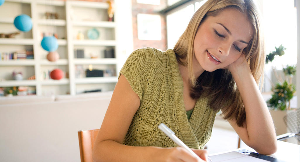 woman smiling and taking notes