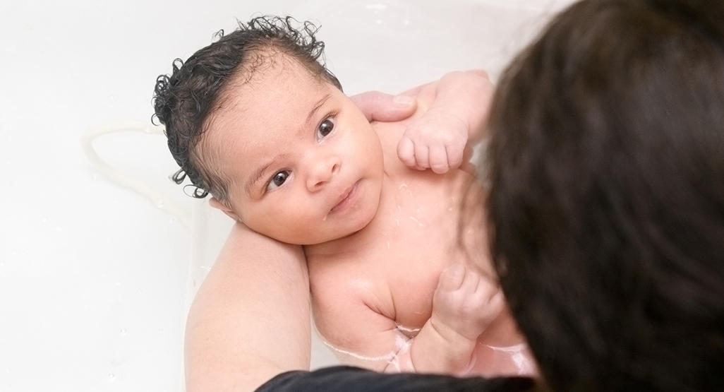 someone bathing a baby