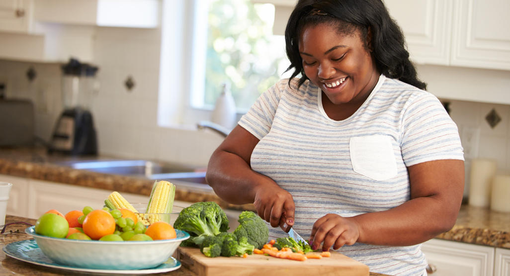 woman cutting broccoli and carrots