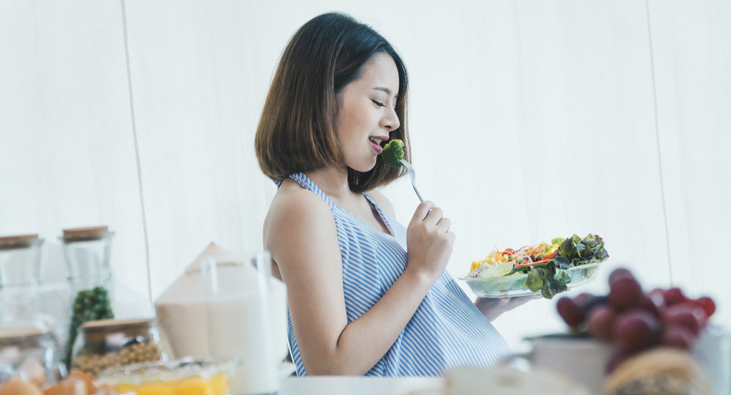 pregnant woman eating broccoli