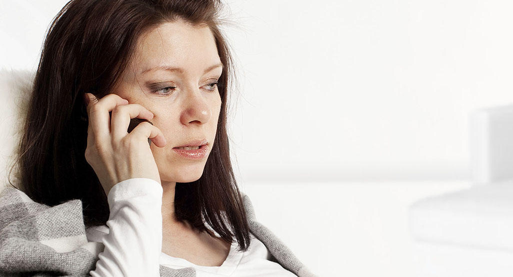 woman looking worried while talking on a mobile phone