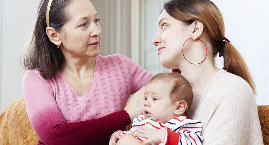 mother holding baby and talking to grandmother