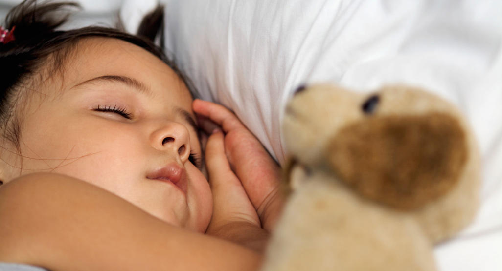 child sleeping with a dog plush toy