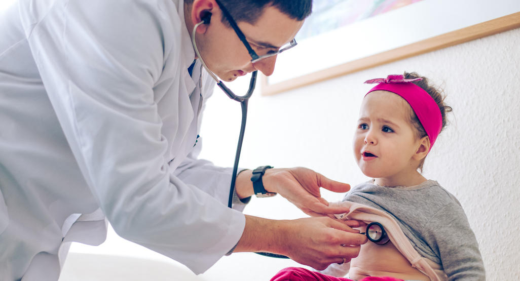 doctor checking girl's tummy with a stethoscope