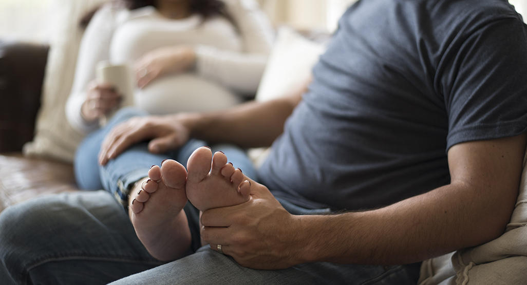 man massaging his girlfriend’s foot