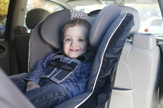 baby boy sitting in a safety car seat