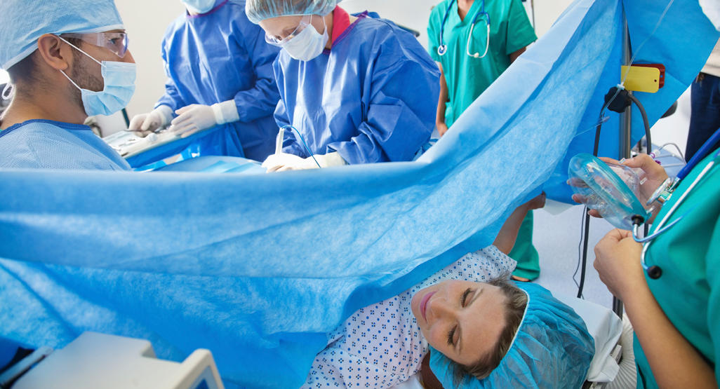 pregnant woman in hospital being prepped for c section by surgical team