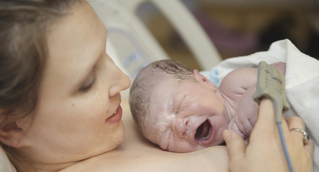 mother holding a newborn immediately after birth