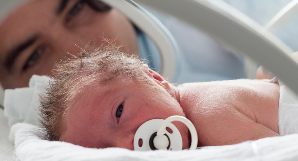 mother laying in hospital bed with newborn baby