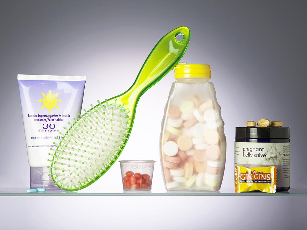 pregnancy medicine set: sunscreen lotion, hairbrush, medical tablets and a pregnant belly salve