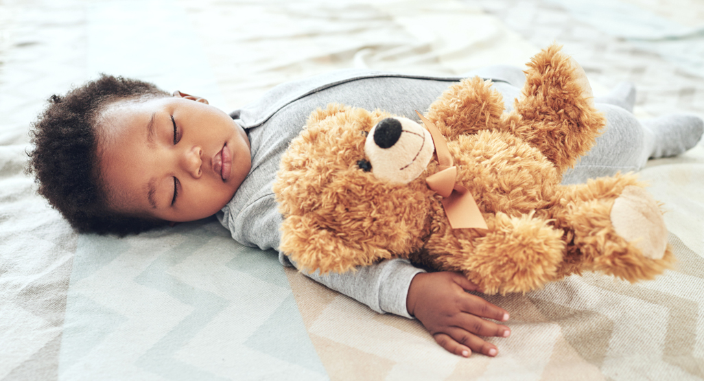 Baby sleeping holding a teddy bear