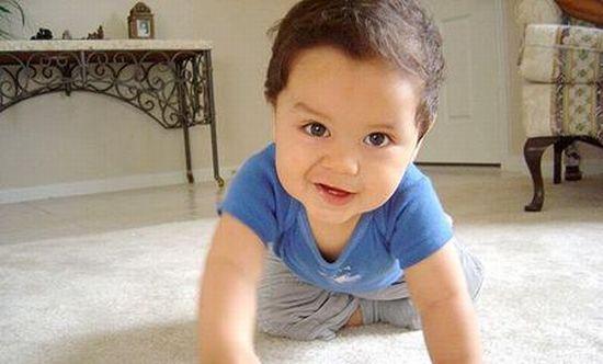 boy crawling on the floor, looking happy