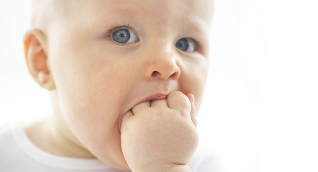 baby putting fingers in mouth