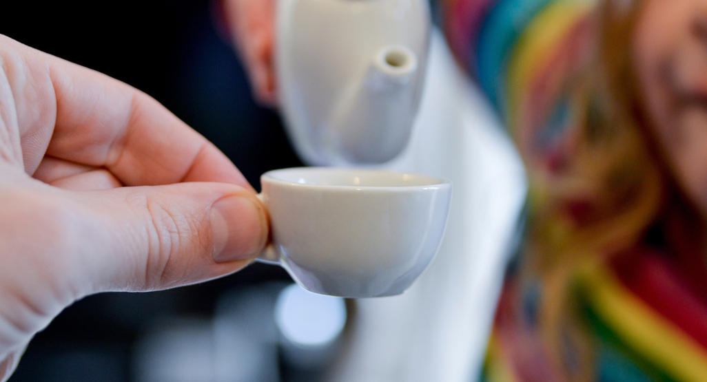 a hand holding miniature cup of coffee